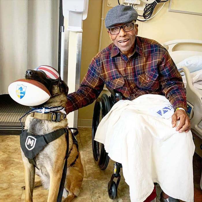 Vet Hero in Hospital wheelchair with Service Dog beside him