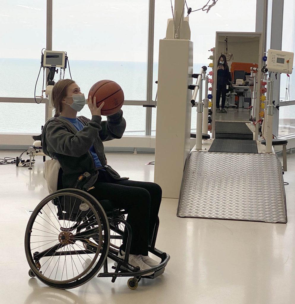 Injured veteran hero shooting basketball sitting in wheelchair in medical room